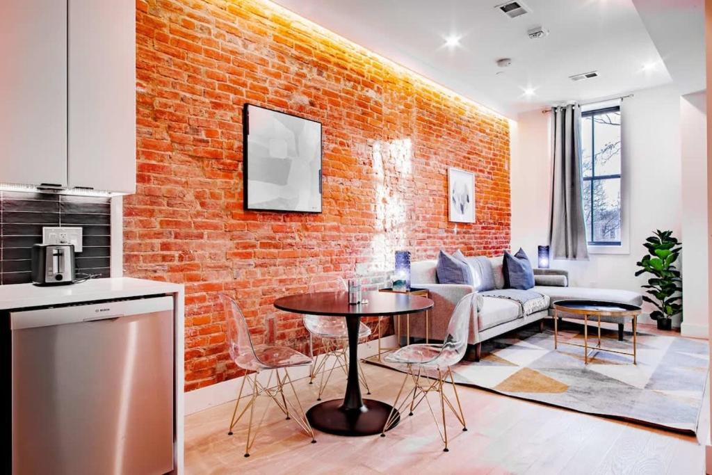 a kitchen and living room with a brick wall at Barracks Row & Eastern Market Oasis Transit-Friendly in Washington, D.C.
