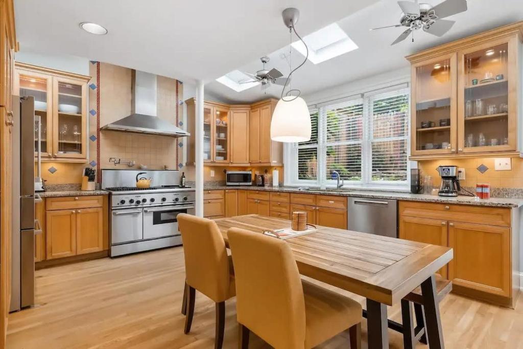 a kitchen with wooden cabinets and a wooden table and chairs at Historic & Modern Capitol Hill 2-BR Row Home in Washington, D.C.