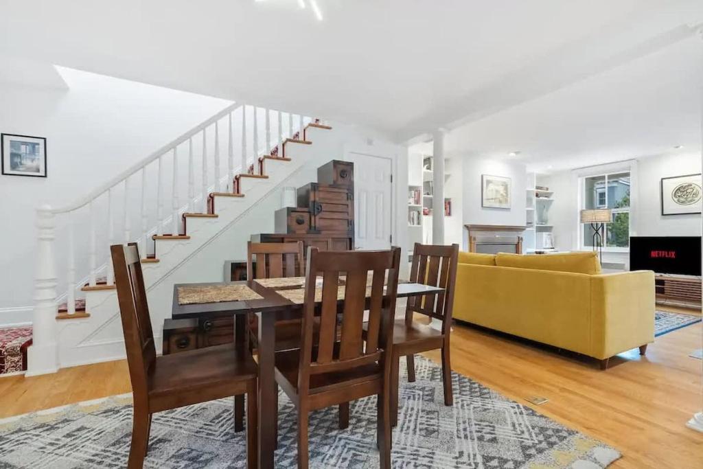 a living room with a dining table and a yellow couch at Historic & Modern Capitol Hill 2-BR Row Home in Washington, D.C.
