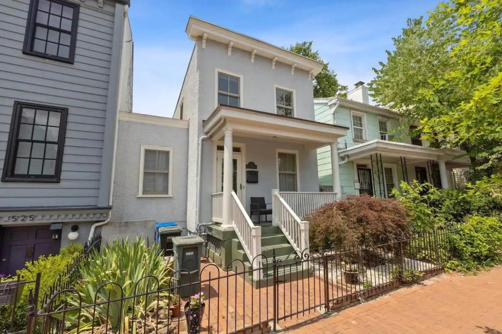 a white house with a fence in front of it at Historic & Modern Capitol Hill 2-BR Row Home in Washington, D.C.