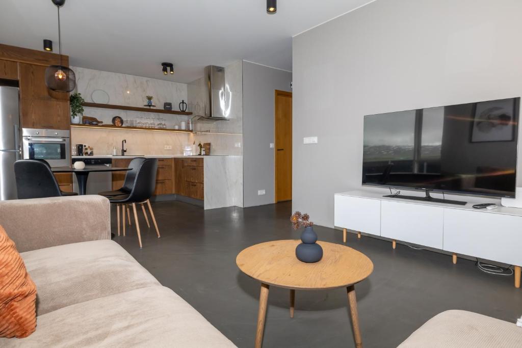 a living room with a couch and a table at Family apartment hosted by LL in Akureyri