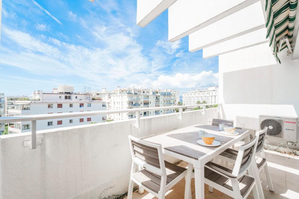 Elle comprend un balcon blanc avec une table et des chaises. dans l'établissement Studio Velasquez - Welkeys, à Cannes