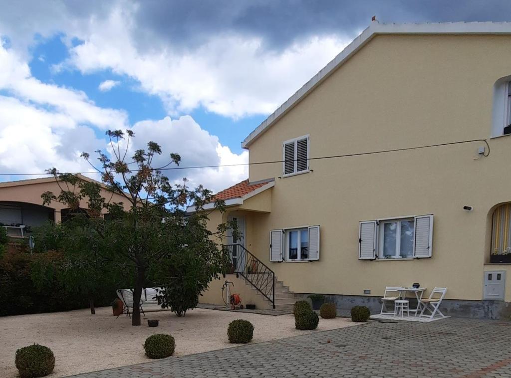 a house with a table and a chair in front of it at Apartment Stella Casa Bruno in Vrsi