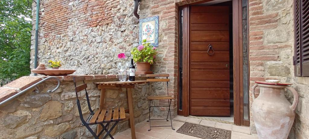 a patio with a table and a wooden door at SerenaHouse in Radicondoli