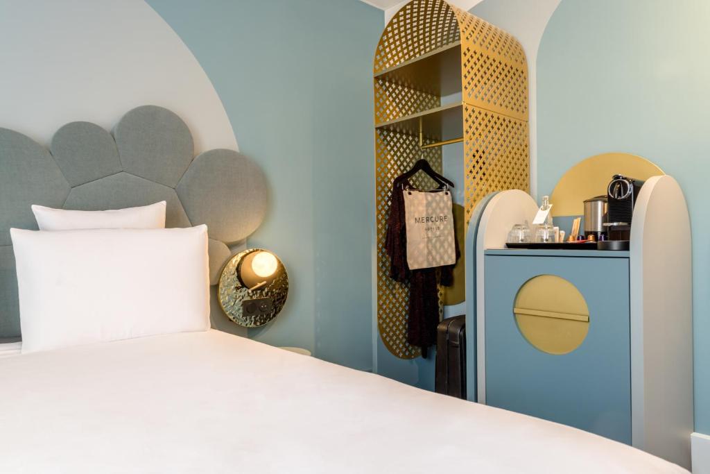 une chambre avec un lit et une étagère dans l'établissement Mercure Annecy Centre, à Annecy