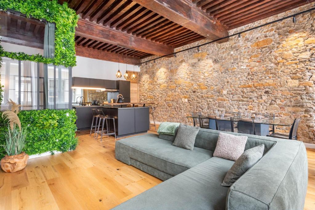 a living room with a couch and a brick wall at Les Balcons de Guignol in Lyon