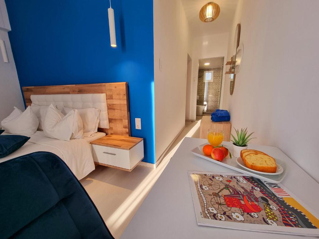 a bedroom with a bed and a plate of food on a table at Hotel Nefeli in Volos