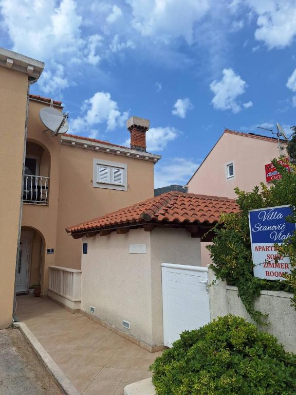 a house with a garage and a sign in front of it at Guesthouse Villa Stanovic Vlaho in Cavtat