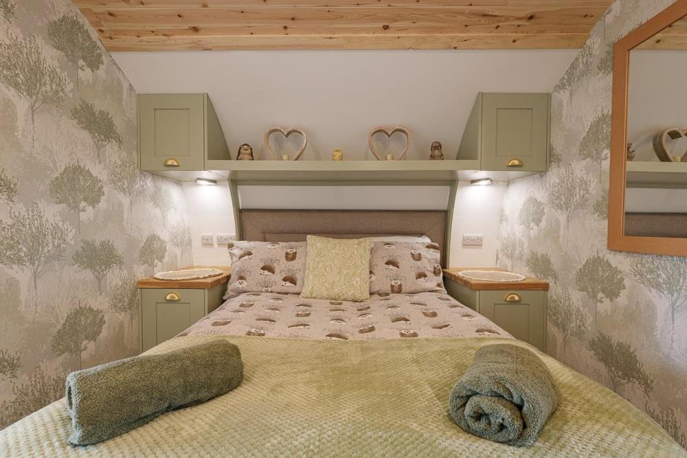 a bedroom with a large bed and some shelves at The Galloway Steading -The Hedgehog's Hideout family cabin with Hot Tub and Fire Pit in Glenluce