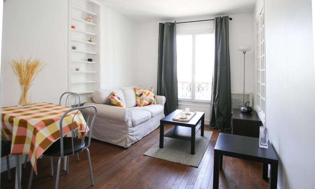 un salon avec un canapé et une table dans l'établissement Batignolles toits de paris, à Paris