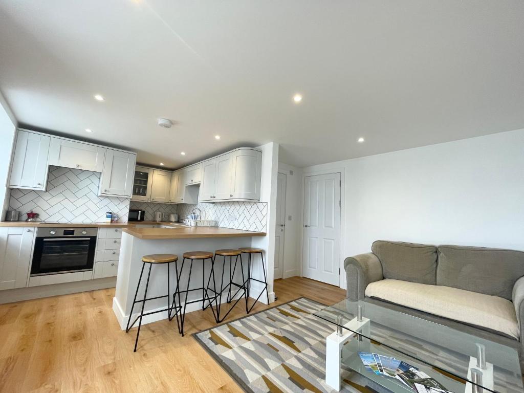 une cuisine et un salon avec un canapé et une table dans l'établissement New~Breathtaking Bay Views~Chapel Street~Penzance, à Penzance