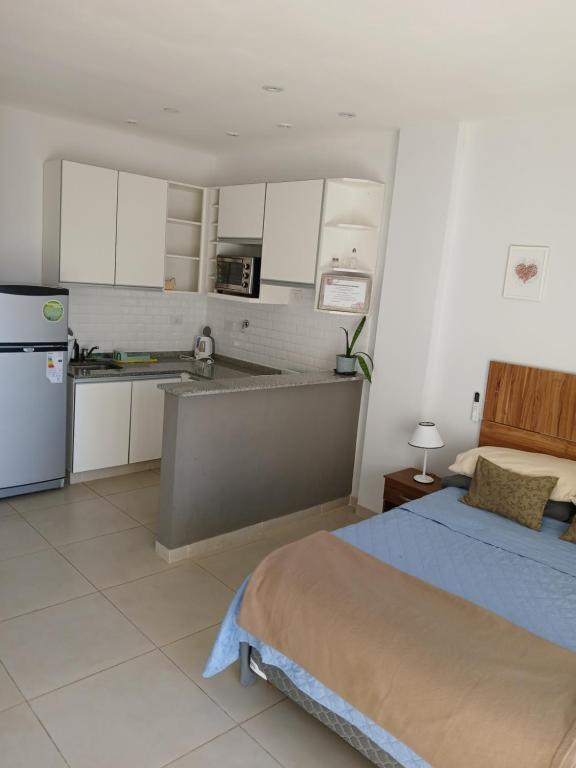 a large bedroom with a bed and a kitchen at Dpto en Costanera, excelente ubicación in Corrientes