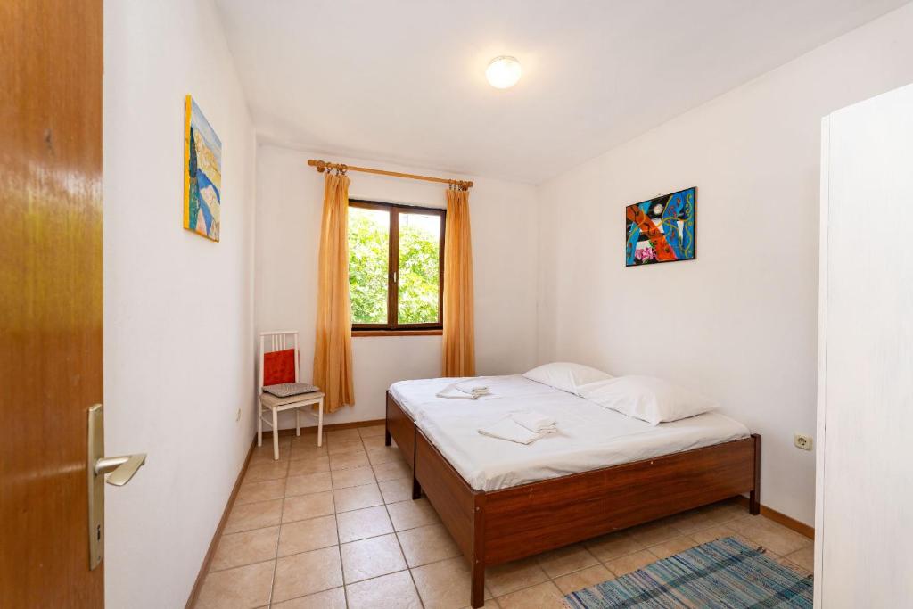 Un dormitorio pequeño con una cama y una ventana. en Dodo Sea View Apartments, en Novalja