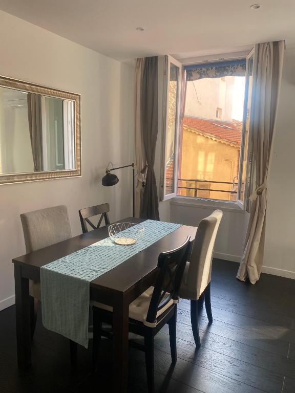 une salle à manger avec une table et des chaises et une fenêtre dans l'établissement Agréable T2 rénové, Cannes centre, Suquet, plages, à Cannes