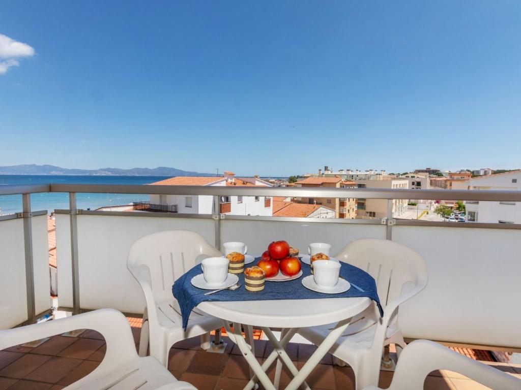 a table with a bowl of fruit on a balcony at Apartment Fénix Marina by Interhome in L'Escala