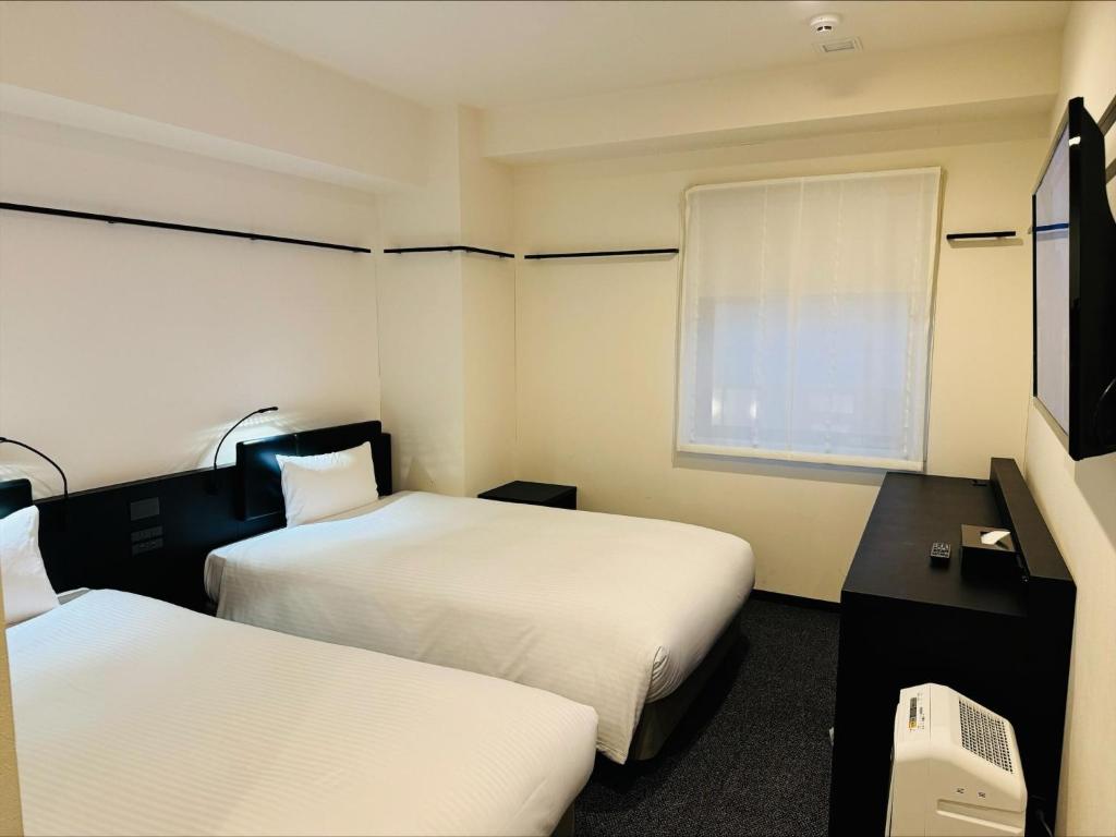 Postel nebo postele na pokoji v ubytování HOTEL SUI KANDA by ABEST