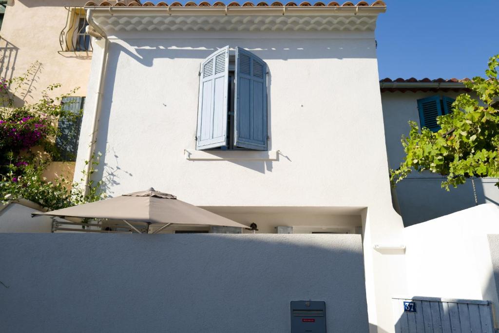 - un bâtiment blanc avec une fenêtre et un parasol dans l'établissement Le Cabanon de Marius, à Six-Fours-les-Plages