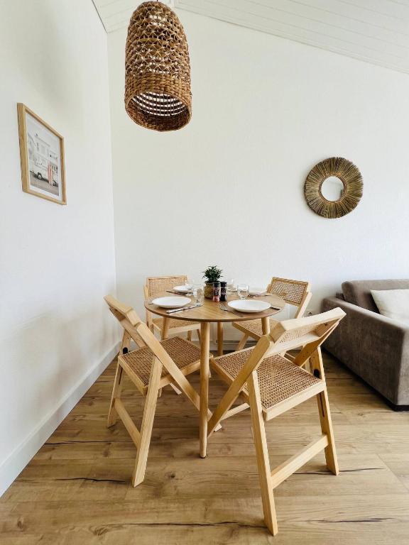 une table et des chaises en bois dans un salon dans l'établissement Le Baromètre - logement chaleureux, à Talmont-Saint-Hilaire