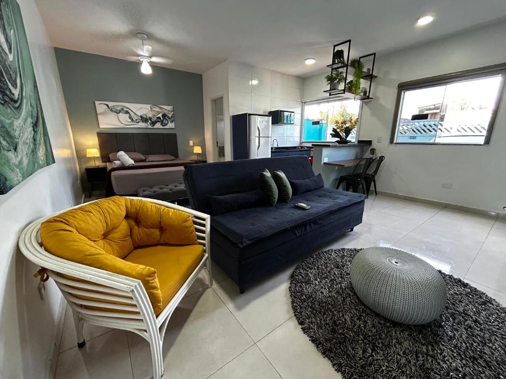 a living room with a couch and a chair and a table at Mangata Loft - Requinte e Conforto para Lazer ou Trabalho in Itanhaém