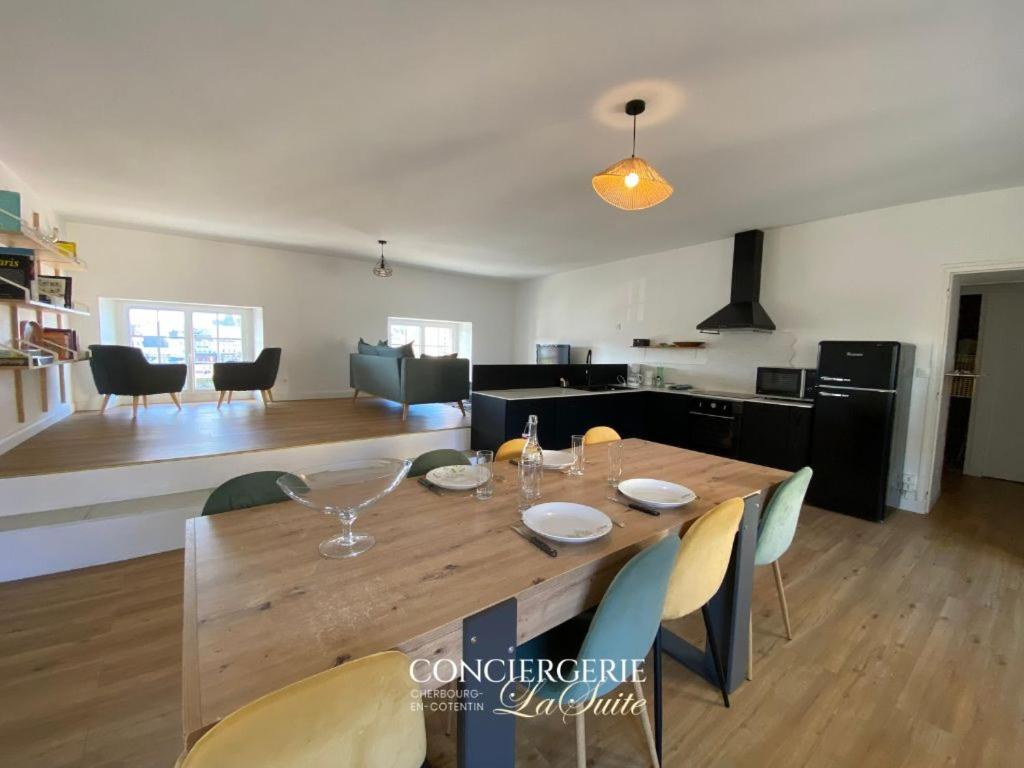 - une salle à manger et une cuisine avec une table et des chaises en bois dans l'établissement L'Escale Cherbourgeoise, à Cherbourg en Cotentin