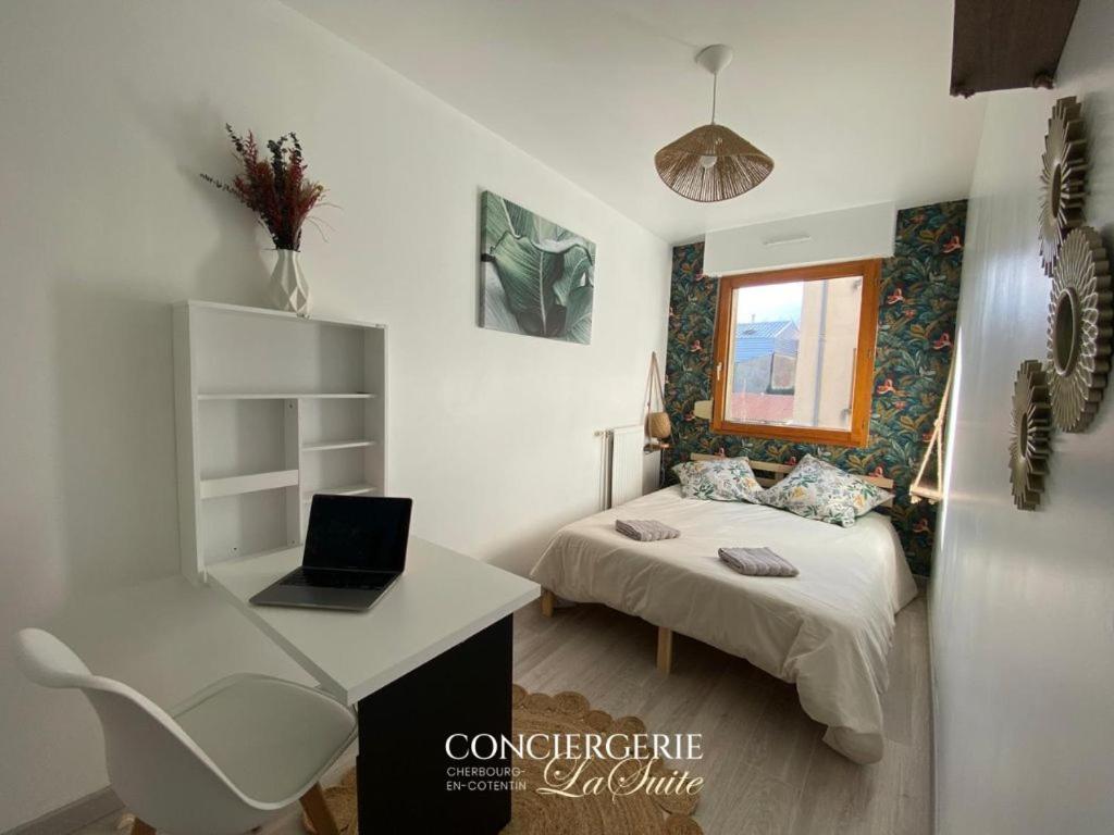 une chambre avec un lit et un bureau avec un ordinateur portable dans l'établissement Le Cocon, à Cherbourg en Cotentin