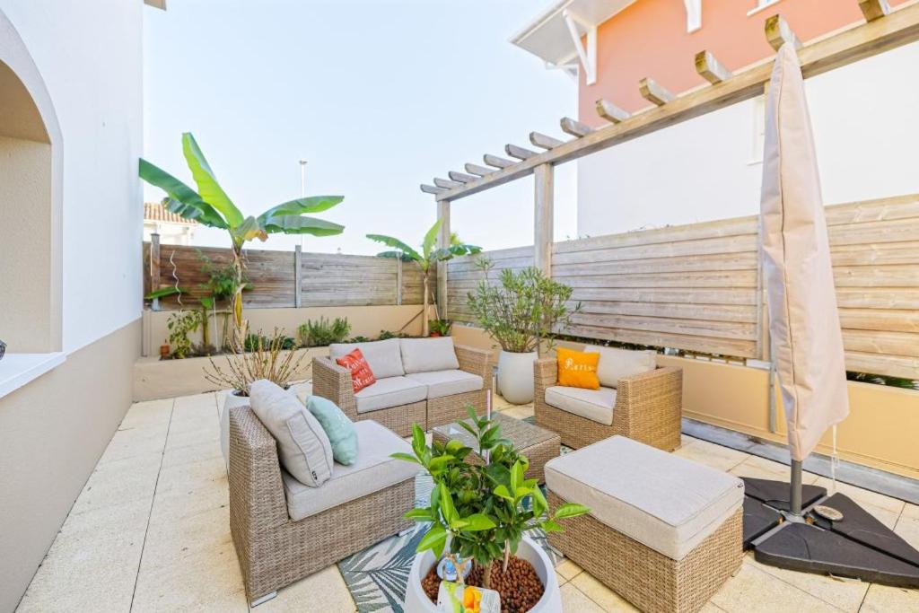 d'une terrasse avec des canapés et des chaises sur un balcon. dans l'établissement Grand appartement avec jacuzzi et terrasse de 55m2, à Bayonne