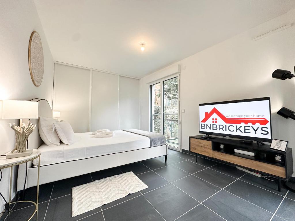 une chambre avec un lit et une télévision à écran plat dans l'établissement Krystal Garden, Bnbrickeys., à Beausoleil