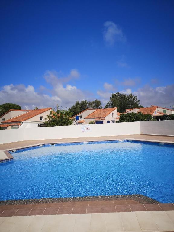 une grande piscine bleue devant une maison dans l'établissement Vacances à Vic avec piscine collective, à Vic-la-Gardiole