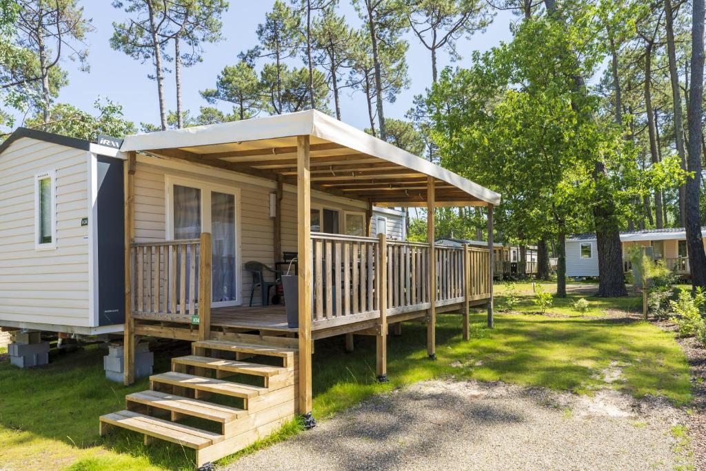 Una pequeña casa con porche y terraza. en Camping Les Oyats, en Seignosse