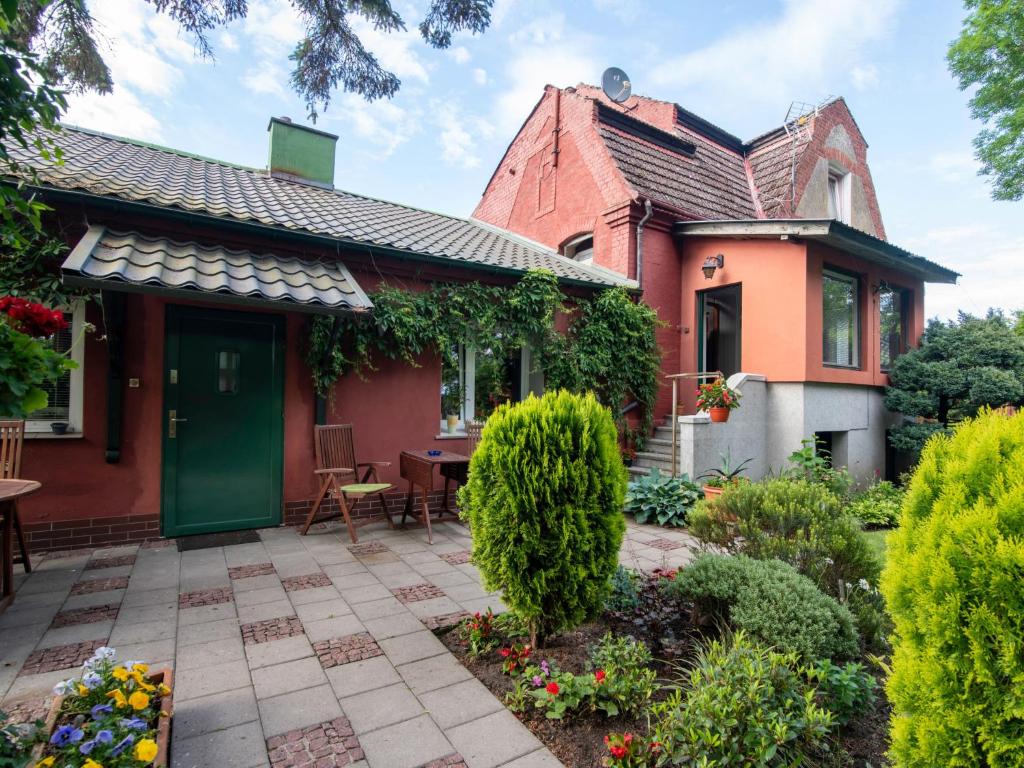 a brick house with a green door and a patio at Apartment Rekowo-1 by Interhome in Kamień Pomorski