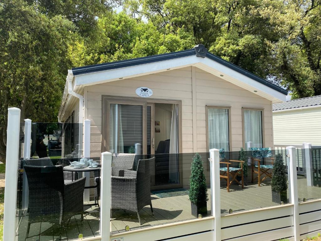 a small house with a deck and a table at Sea Shore Lodge Mudeford in Christchurch