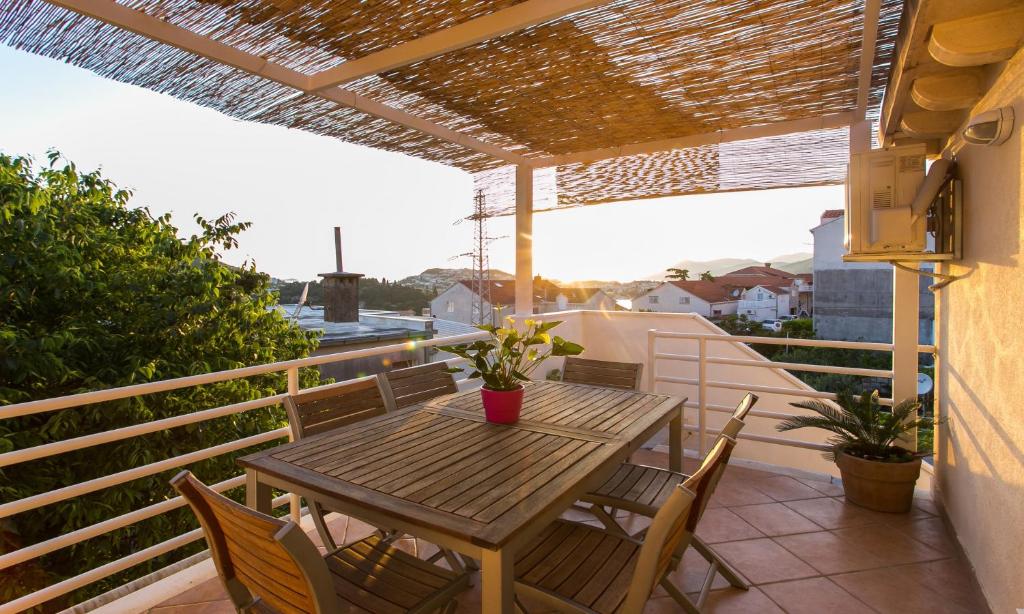 a wooden table and chairs on a balcony at Apartment Marlo in Dubrovnik