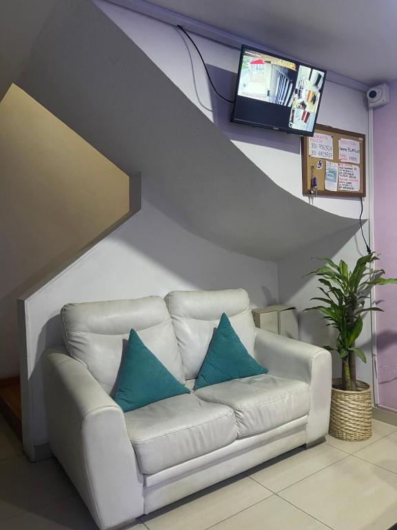 a white couch with blue pillows in a living room at A 5 minutos de Aeropuerto Dorado in Bogotá