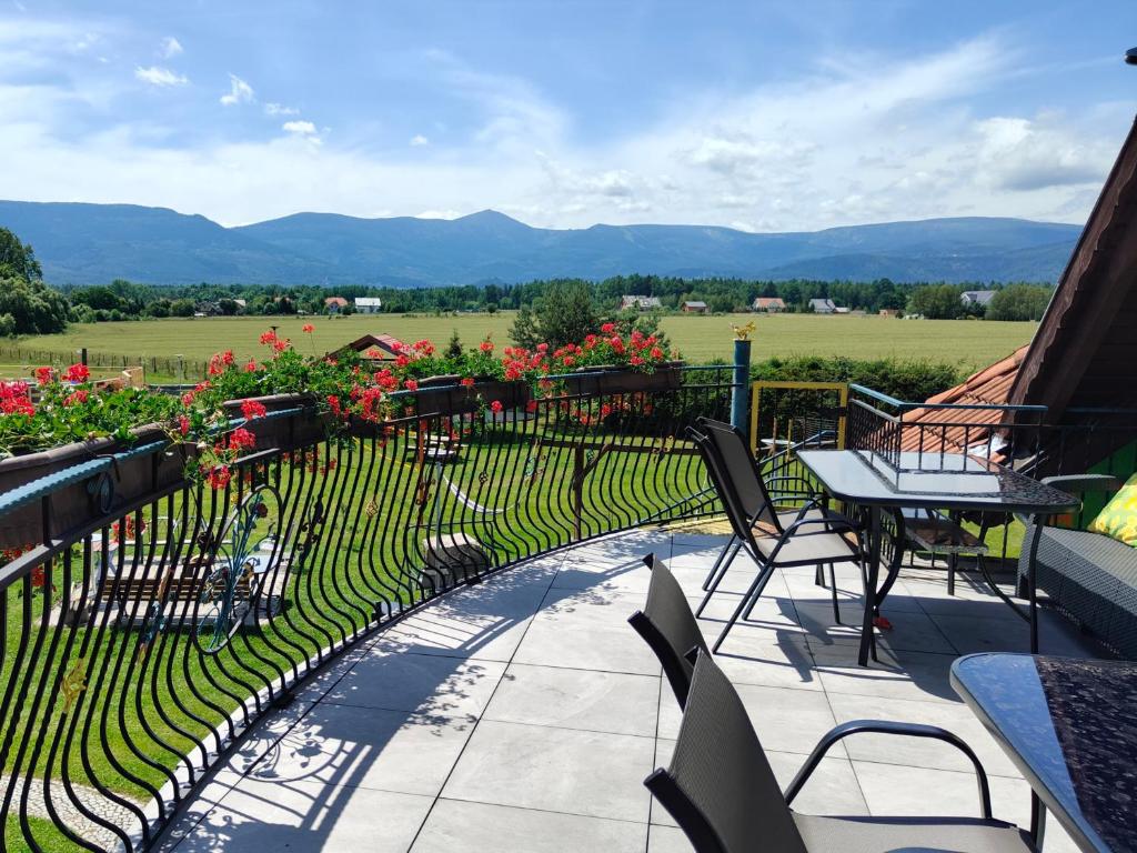 a balcony with a table and chairs and flowers at Willa Kolorowa Chata 6 km Od Karpacza in Mysłakowice