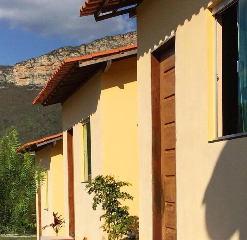 een gebouw met een deur en een berg op de achtergrond bij Pousada Mont Hebrom in Ibicoara