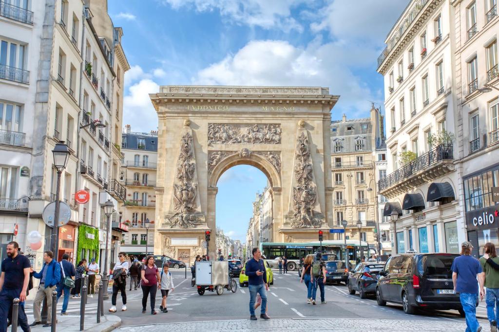 Une foule de gens marchant devant l'arc de triomphe dans l'établissement Elegant Triplex in Paris - Ideal for 10 - Aircon, à Paris