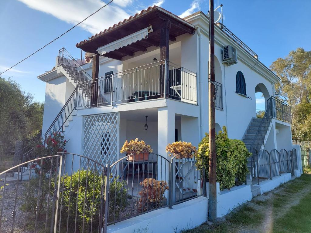 a white house with stairs and potted plants at Deiana's Apartment - Cardedu Beachside in Cardedu