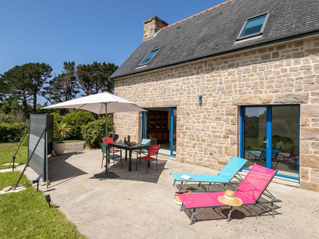 Un patio con una mesa y sillas y una sombrilla. en Holiday Home Rivage by Interhome, en Trégastel