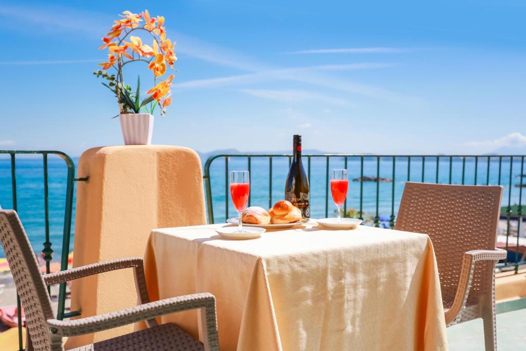 a table with a bottle of wine and a plate of food at Hotel Rivamare in Ischia