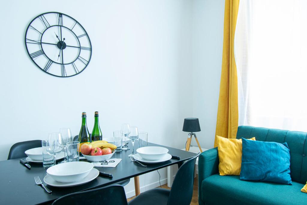 une salle à manger avec une table et une horloge murale dans l'établissement Le Cœur Brestois I hypercentre & 5 min de la gare, à Brest