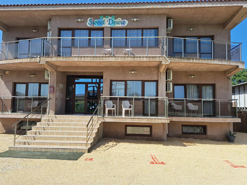 a building with a balcony with chairs on it at Sweet Desire in Vama Veche