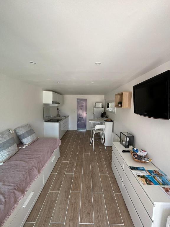 une chambre avec un grand lit et une télévision à écran plat dans l'établissement Studio thalie, à Bormes-les-Mimosas