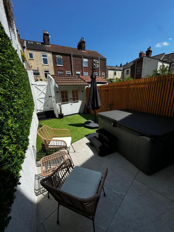 a patio with two chairs and a table and a grill at Luxe City Hot Tub: Urban Retreat in Norwich