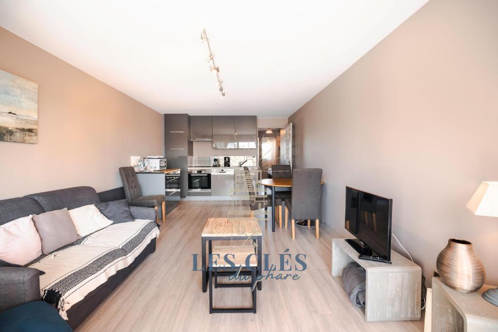 Il comprend un salon doté d'un canapé et d'une table avec une télévision. dans l'établissement Greenwich, à Le Touquet-Paris-Plage