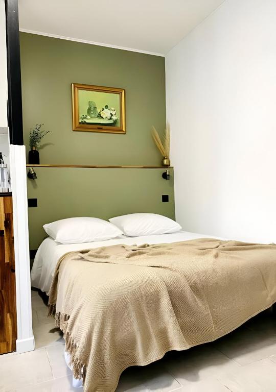 - une chambre avec 2 lits et un mur vert dans l'établissement Studio mosaïque Narbonne, à Narbonne