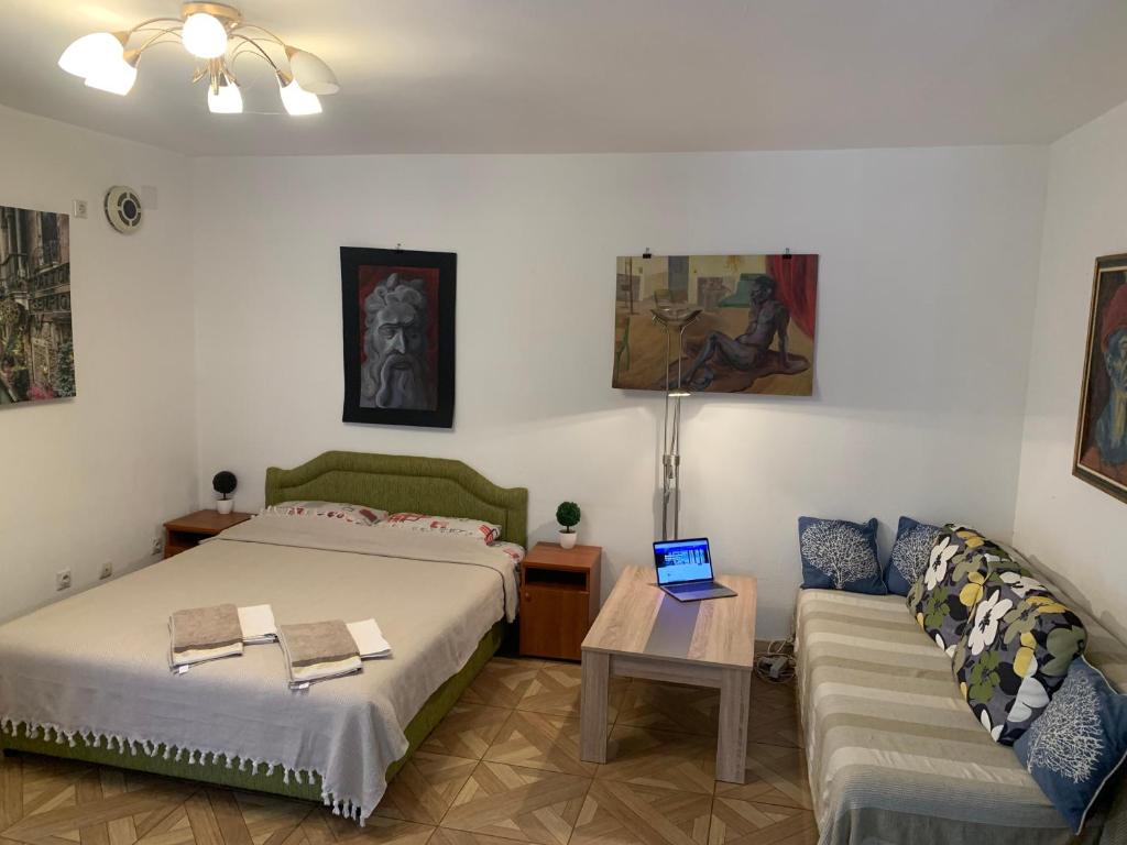 a bedroom with a bed and a couch and a laptop at Axenia Hotel in Utjeha