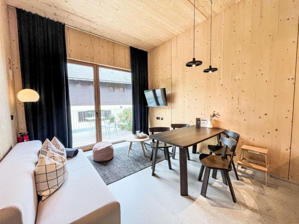 een woonkamer met een tafel en een bank bij Apartment Hideaway Planneralm by Jufa Hotels-1 by Interhome in Planneralm