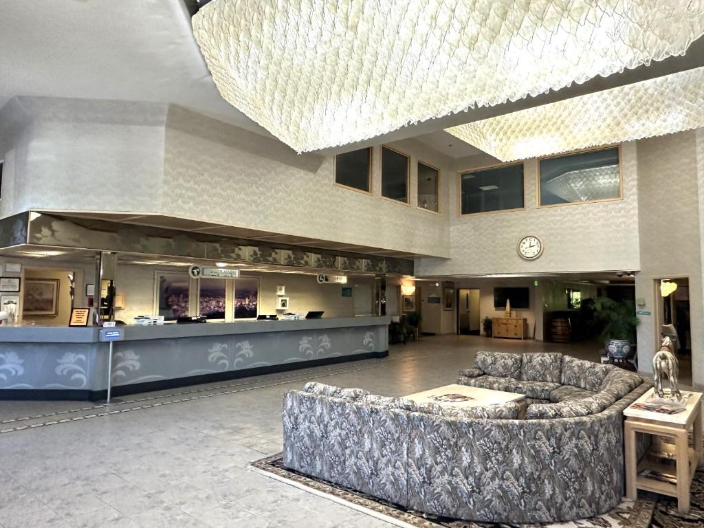 a large lobby with a couch and a bar at Sojourn Suites Portland Airport in Portland