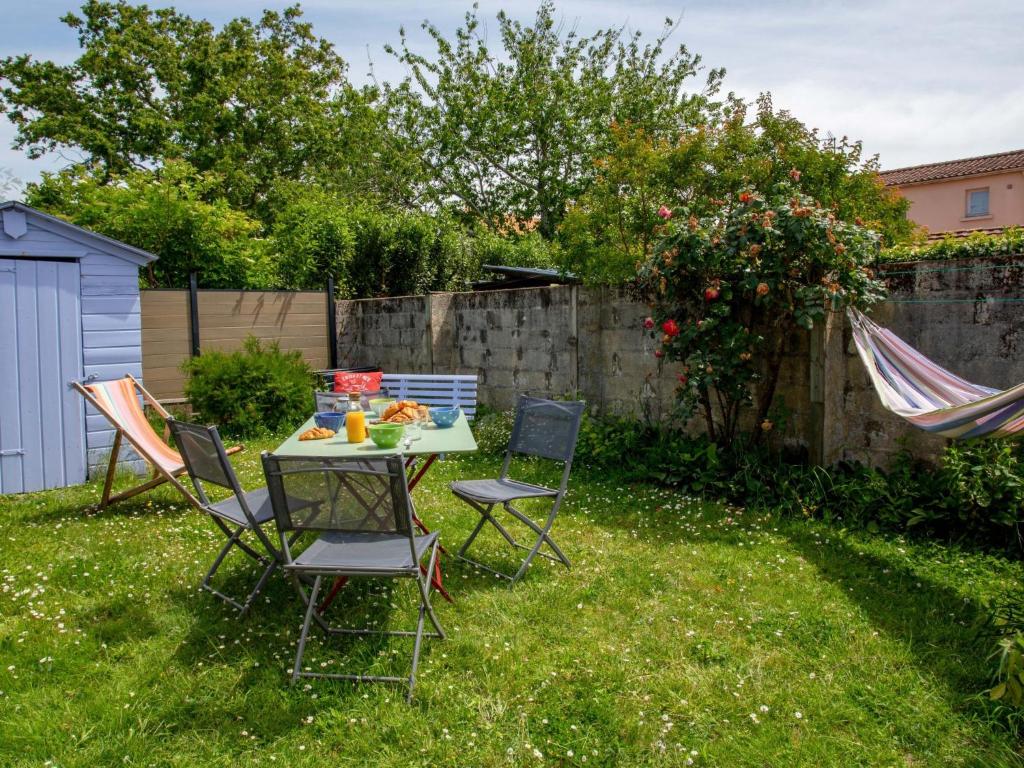 d'un jardin avec une table et des chaises dans la pelouse. dans l'établissement Holiday Home La Maison du Pêcheur by Interhome, à Pornic