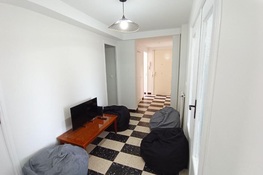 un salon avec deux poufs et une télévision dans l'établissement Apartment with terrace near the sea, à Nice